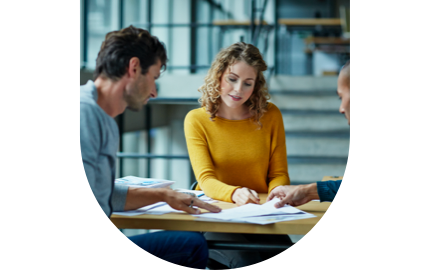 Three persons in an office pointing and reading a paper Three persons in an office pointing and reading a paper