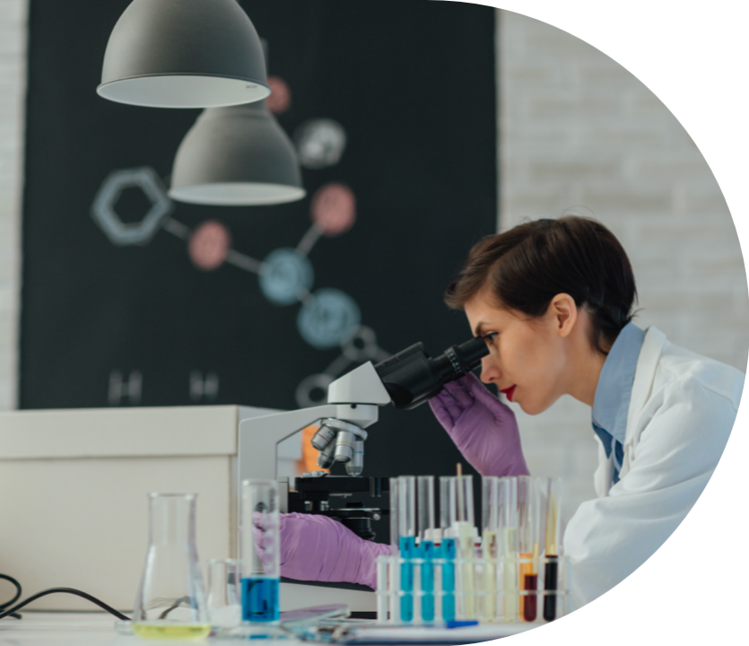 Woman in a laboratory looking into a microscope Woman in a laboratory looking into a microscope